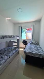 卡马萨里casa confortável的一间卧室配有两张双层床和椅子