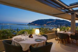 阿拉尼亚Büyük Hotel的一间设有桌椅的海景餐厅
