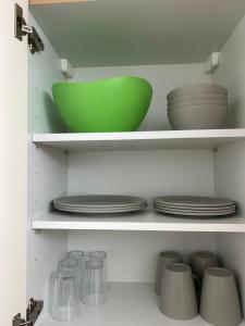 法伦达尔Vallendarer Stübchen的厨房里架子上的一个绿色碗和盘子