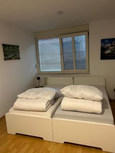 法伦达尔Vallendarer Stübchen的客房内的一张白色床和两个枕头