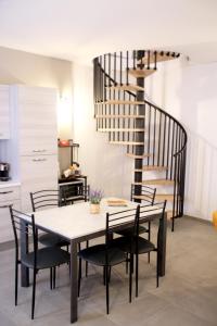 洛雷托Giolo House的一间带桌椅的用餐室和螺旋楼梯