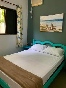 瓜鲁雅Alma de Maré Hostel的一间卧室配有一张蓝色床头板的床