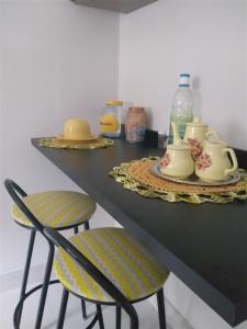 圣洛伦索Casa Gómez的一个带两把椅子的柜台和一张桌子,桌子上装有杯子和瓶子