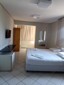 福塔莱萨博里斯公寓酒店 的一间卧室配有一张床和一台电视