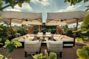米兰米兰宝格丽酒店的配有白色家具和遮阳伞的庭院