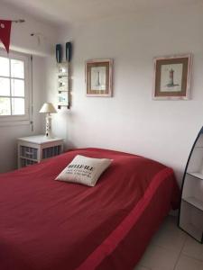 班戈Maison "Ker Galinette " , Belle-Ile-En-Mer, Piscine chauffée et Jacuzzi的一间卧室配有一张带红色毯子的床