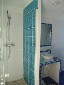 班戈Maison "Ker Galinette " , Belle-Ile-En-Mer, Piscine chauffée et Jacuzzi的蓝色瓷砖浴室设有水槽和淋浴