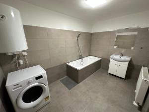 尼赖吉哈佐City Apartman的浴室配有卫生间、浴缸和水槽。