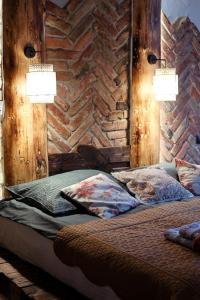 下乌斯奇基PORANEK W GÓRACH的一间卧室设有砖墙和一张带两个灯的床