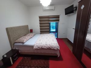 PodlugoviHollywood Motel的一间卧室配有一张大床和红地毯
