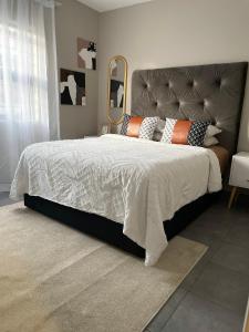 米德兰Central and peaceful 2-bedroom Apt #ZonaHomes的一间卧室配有一张大床和镜子