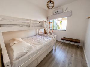 圣塞巴斯蒂安Casa Piscina Aquecida Canto Del Mare的一间卧室设有两张双层床和一扇窗户。
