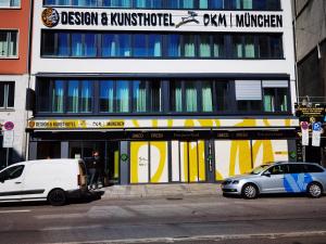 慕尼黑Design- und Kunsthotel München的两辆汽车停在大楼前