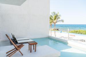 女人岛Villa Saadhu with fantastic oceanview的一个带游泳池和椅子的房间,享有海景