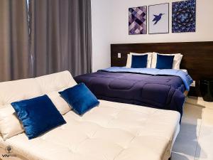 圣保罗Sweet Home - Vivare Augusta的一间卧室配有一张床和一张带蓝色枕头的沙发