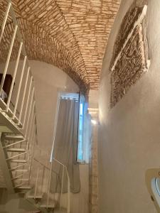 马丁纳弗兰卡PalazzOliva - Boho chic Guest house in the historic heart of Martina Franca的砖砌天花板房子的楼梯