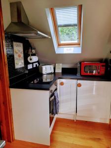 斯托灵顿Pinecroft Barn - Relax & Unwind!的一间小厨房,厨房的柜台上装有红色微波炉