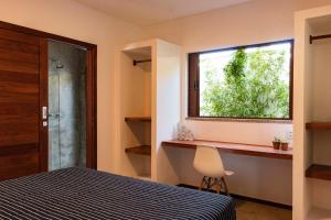 圣米格尔-杜戈斯托苏Vila de Charme的卧室设有窗户、一张床和椅子