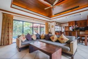 拉威海滩Lotus Pool Villa的客厅配有沙发和桌子