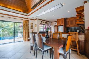 拉威海滩Lotus Pool Villa的厨房以及带木桌和椅子的用餐室。