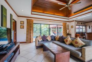 拉威海滩Lotus Pool Villa的带沙发和电视的客厅