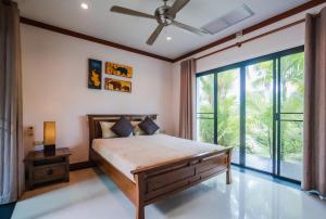 拉威海滩Lotus Pool Villa的一间卧室设有一张床和一个大窗户