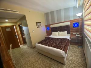 Karaman德莫森酒店的一间位于酒店客房内的带大床的卧室