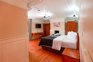 米内拉尔德尔蒙特Hotel Real Del Monte的配有一张床和一张书桌的酒店客房