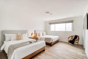 恩塞纳达港Beach House by ULIV的酒店客房,配有两张床和椅子