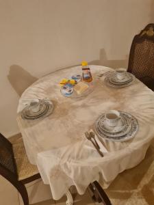 希俄斯Village home的一张带两个杯子和盘子的白色桌子