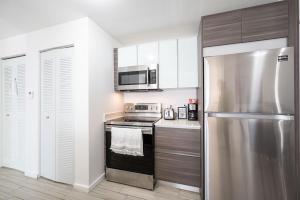 迈阿密Subtle 2 Bed in Edgewater Downtown with Free Parking的厨房配有不锈钢冰箱和微波炉。