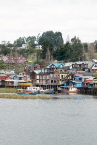 卡斯特鲁Palafito 1326 Hotel Boutique Chiloé的水面上的一群房子和船只