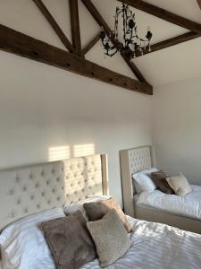 ConisbroughSugar Plum Cottage的一间卧室配有两张床和吊灯。