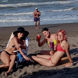 Monte GordoLa Morada, una ventana al golfo - Hotel boutique的三名穿着泳衣的妇女坐在海滩上