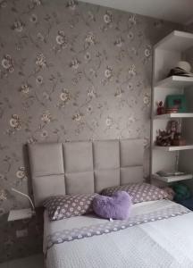 桑托斯Apartamento 2 quartos aconchegante的一间卧室,床上有紫色填充动物