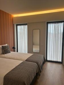 莱萨·达·帕尔梅拉Leça Apartments的酒店客房,设有两张床和镜子