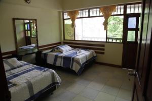 PillcopataParaiso Pilcopata Inn的一间卧室设有两张床和窗户。