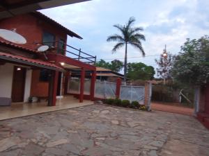 圣安娜杜里亚舒Pousada Central的一座带围栏和棕榈树的房子