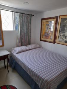 卡塔赫纳Hostal Casa de las Americas的一间小卧室,配有床和窗户
