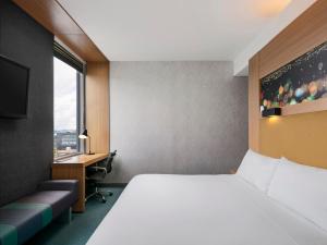 波哥大雅乐轩波哥大机场酒店的配有一张床、一张书桌和一扇窗户的酒店客房