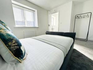 KingsnorthMaize Stylish 3 Bedroom House with Hot tub的一间卧室配有一张带枕头和镜子的床