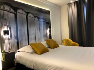 勒阿弗尔贝斯特韦斯特艺术酒店的卧室配有一张白色大床和黄色靠垫