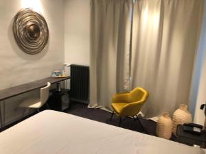 勒阿弗尔贝斯特韦斯特艺术酒店的一间卧室配有一张床和一张黄色椅子