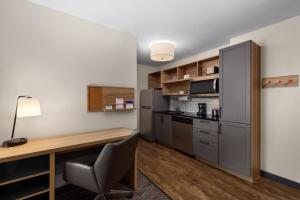 雷顿Candlewood Suites - Layton - Salt Lake City, an IHG Hotel的一间带书桌和冰箱的小厨房