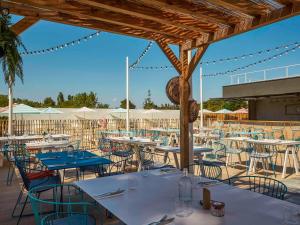 莫吉奥Ibis Styles Montpellier Aéroport Parc Des Expos的一间带桌椅和遮阳伞的餐厅