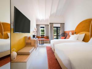 索托格兰德SO/ Sotogrande Spa & Golf Resort Hotel的酒店客房设有两张床和一台平面电视。