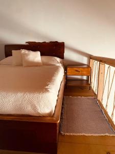 乌蒂拉Utila Water Sports Deluxe Apt的一间卧室配有一张带木制床头板和一张桌子的床。