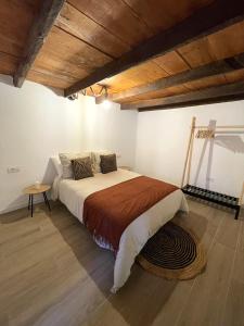 洛斯雷亚莱霍斯calMar Tenerife 1的一间卧室设有一张大床和木制天花板