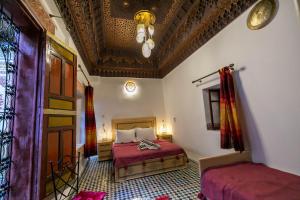非斯Riad Qamar Fez的一间卧室设有一张床和天花板