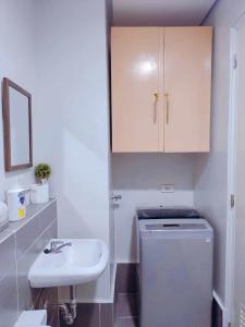 公主港Palawan Paradise Condotel 7F的白色的浴室设有水槽和一台洗衣机